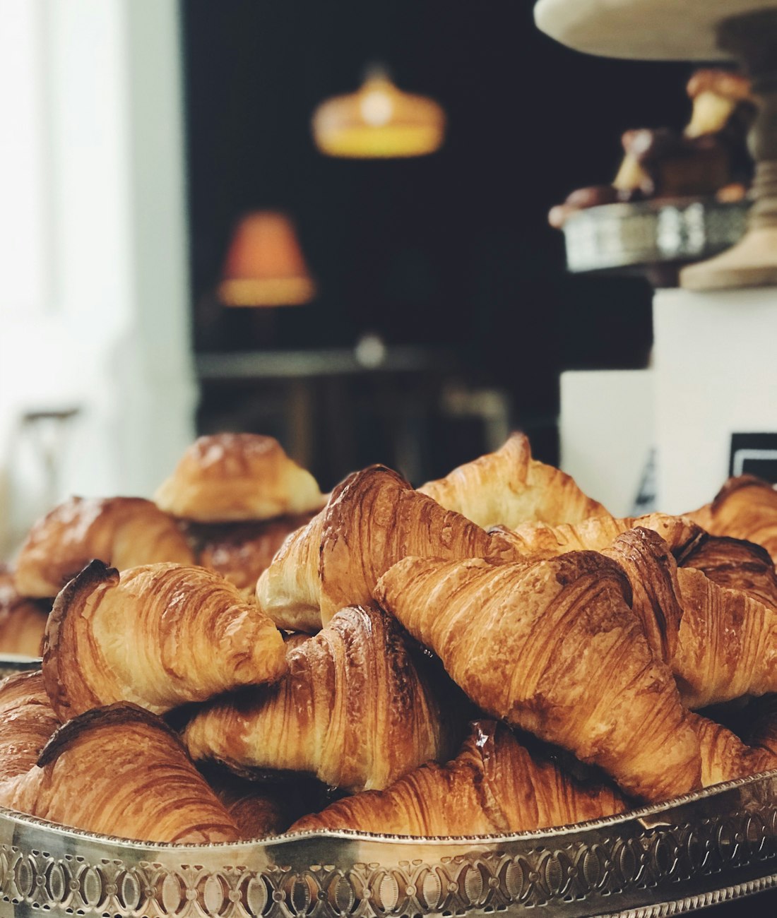 Croissants stacked on a tray in the counter case