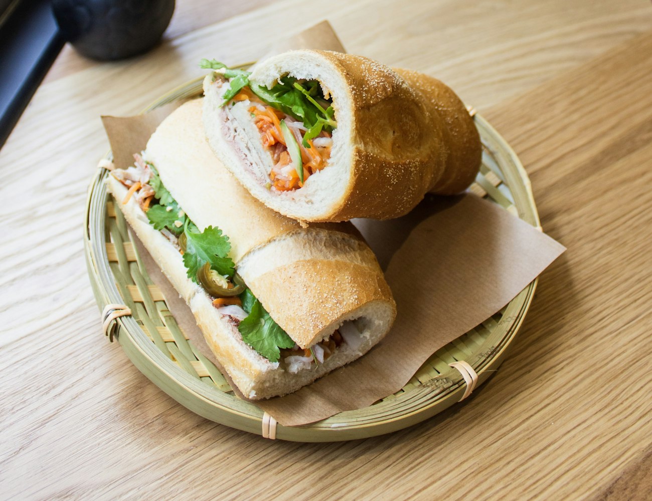 A filled sandwich in a basket at the counter