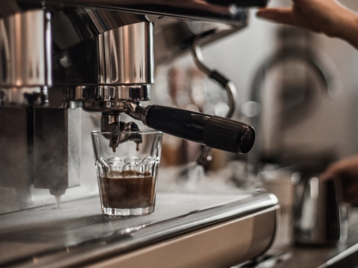 Espresso being pulled into a glass at the chrome machine